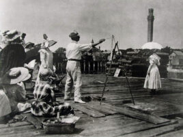 archival image of teacher painting model on the pier while class observes