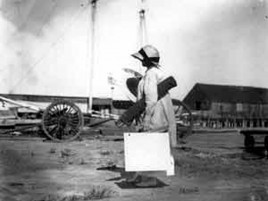 Archival image of a student walking with art supplies